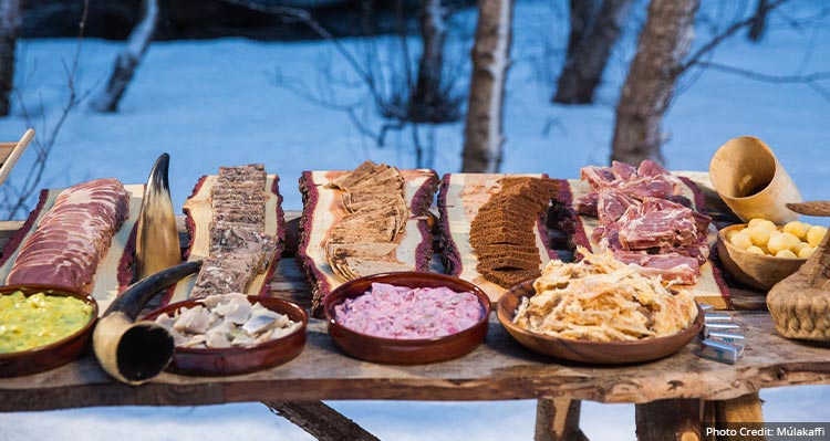 A platter of food on a table in a forest.