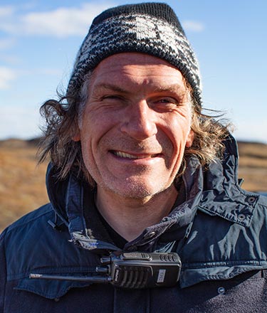 A man with scraggly hair under a winter hat.
